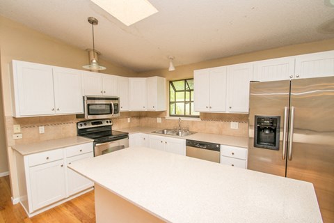 A kitchen with white cabinets and stainless steel appliances.