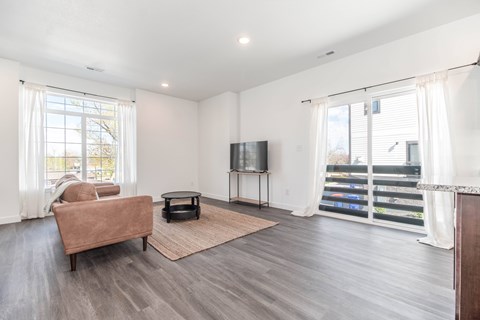 A living room with a brown couch and a flat screen TV.