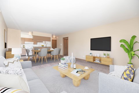 A living room with a grey couch, a wooden coffee table, a dining table with chairs, a television, and a potted plant.