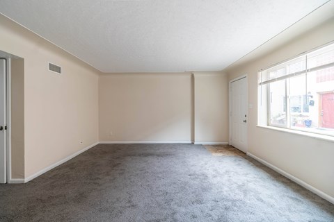 Empty room with grey carpet and white walls.