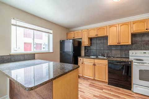 A kitchen with wooden cabinets and black appliances.