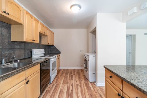 A kitchen with wooden cabinets and a washing machine.