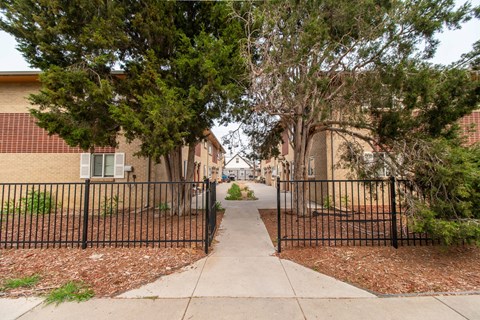 A black iron fence surrounds a sidewalk.