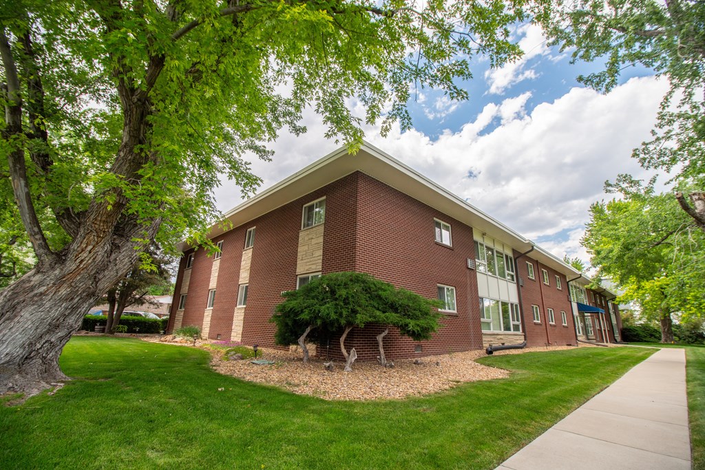 A red brick building with a green lawn in front.