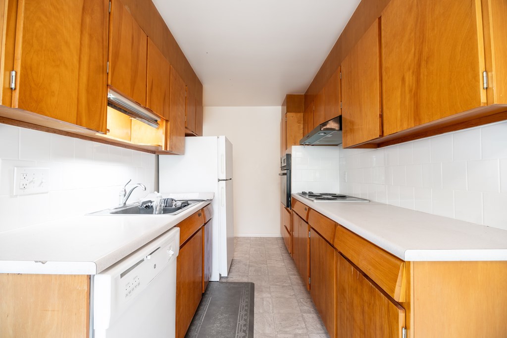 A kitchen with wooden cabinets and white appliances.
