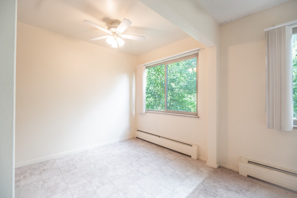 A room with a window and a ceiling fan.