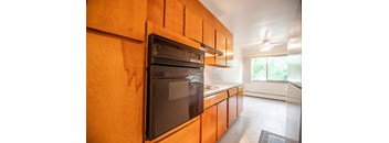 A modern kitchen with wooden cabinets and a black oven.