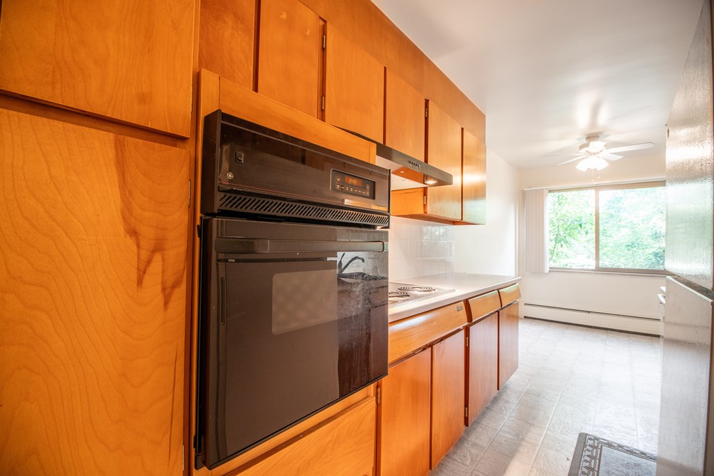 A modern kitchen with wooden cabinets and a black oven.