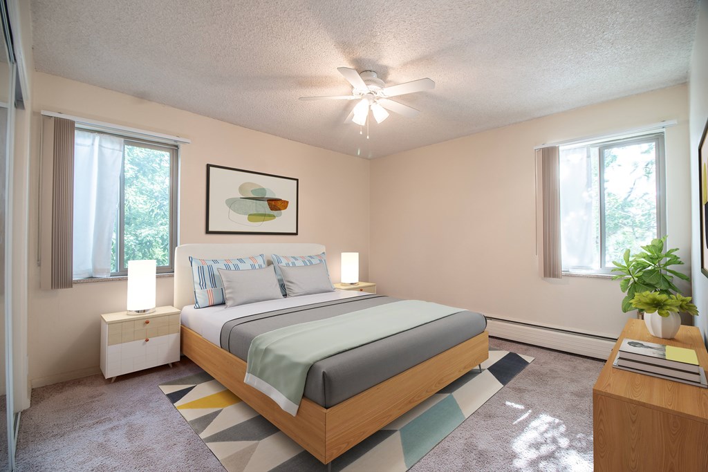A bedroom with a bed, nightstand, and a painting on the wall.