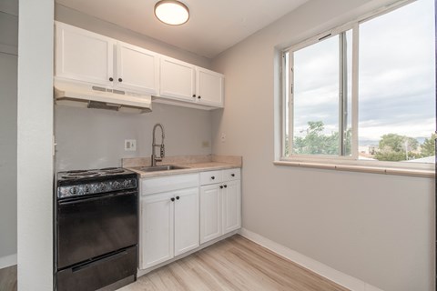 A kitchen with a black stove top oven and white cabinets.