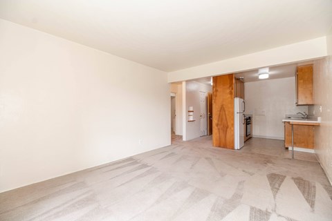 A kitchen area with a refrigerator, sink, and cabinets.