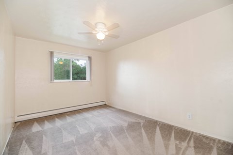 A room with a ceiling fan and a window.