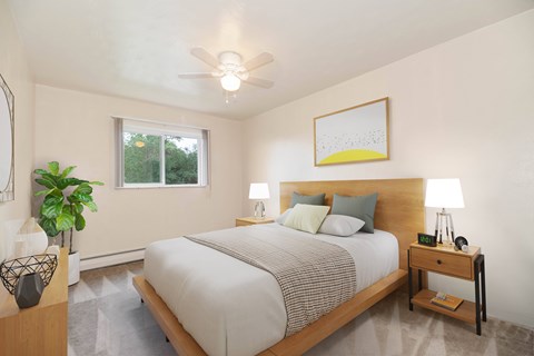 A bedroom with a bed, nightstand, and a plant.