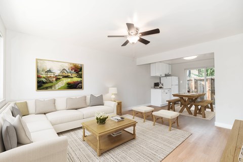 A living room with a white couch, a coffee table, and a painting on the wall.