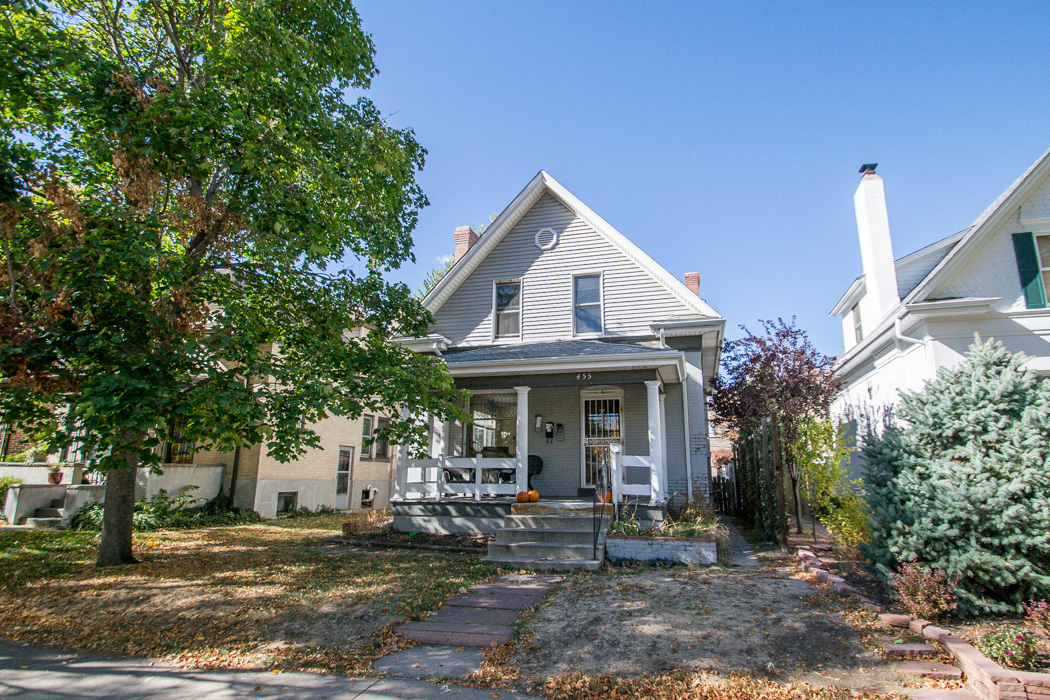 the front of a house with a porch and a tree