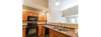 A kitchen with wooden cabinets and a black stove top oven.