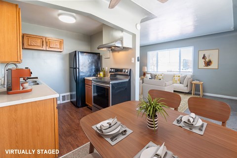 A kitchen with a table set for two and a plant in the middle.