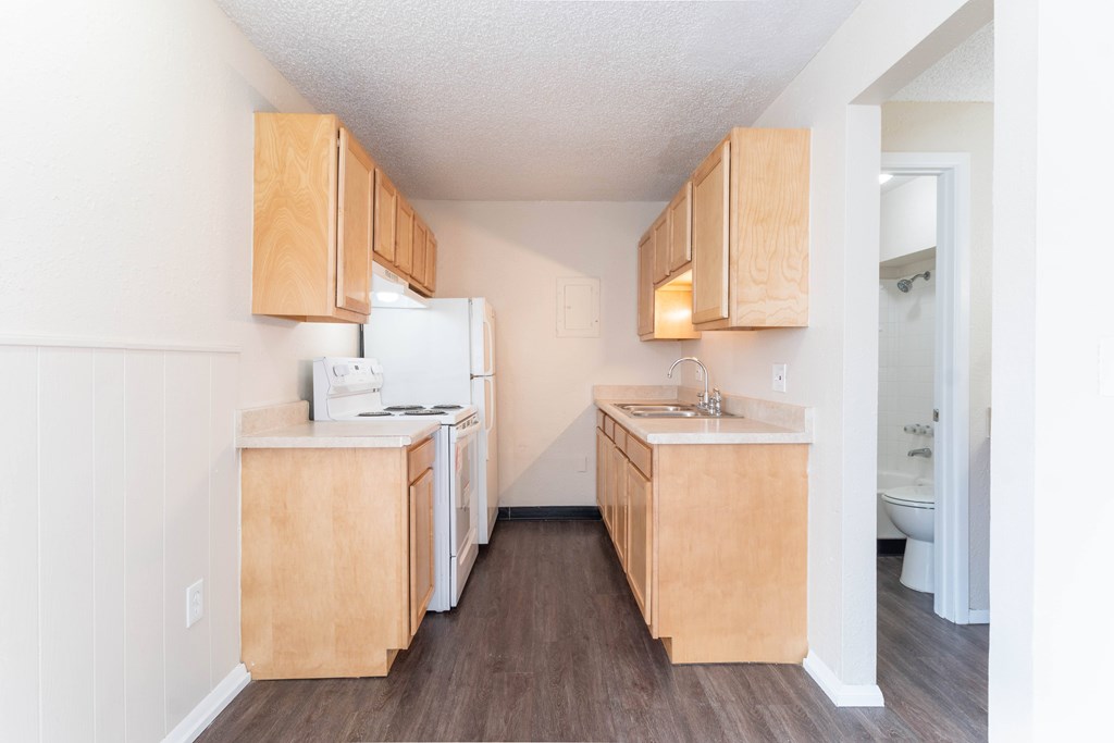 A kitchen with wooden cabinets and a white fridge.