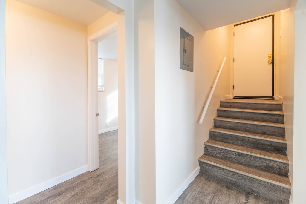 A hallway with a staircase leading to the second floor.