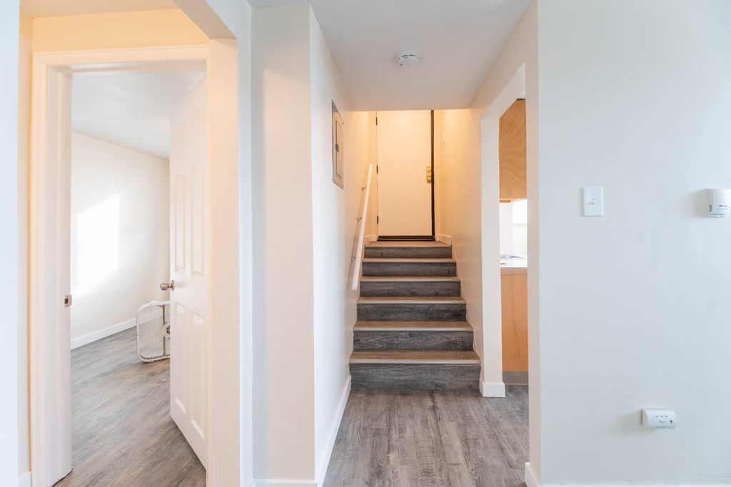 A hallway with a staircase leading to the second floor.