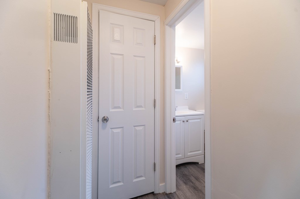 A white door is in a room with a white wall.