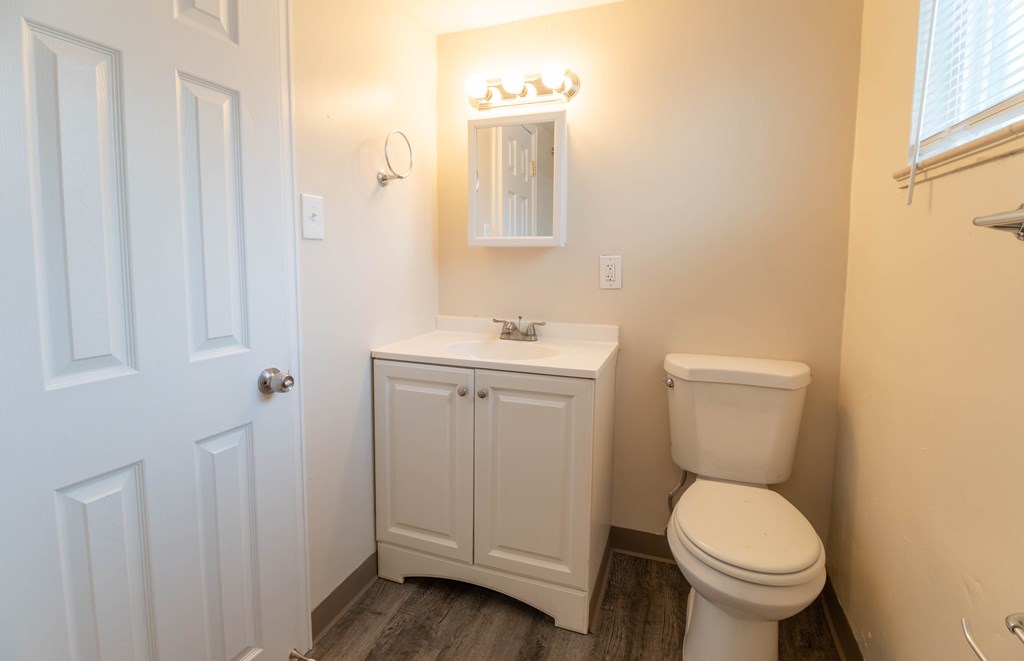 A white toilet sits next to a sink in a small bathroom.