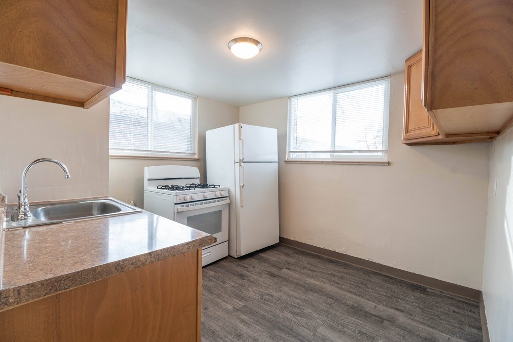 A kitchen with a sink, stove, and refrigerator.