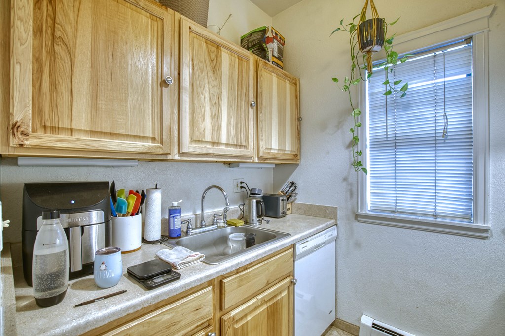 a kitchen with wooden cabinets and a white dishwasher