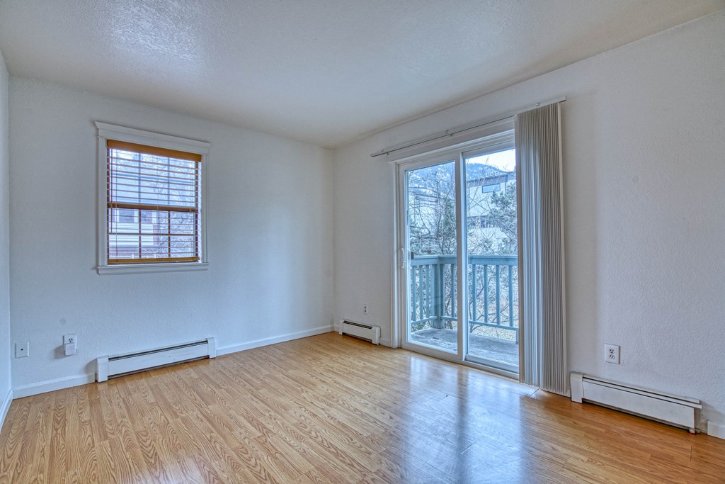a bedroom with a sliding glass door and hardwood floors