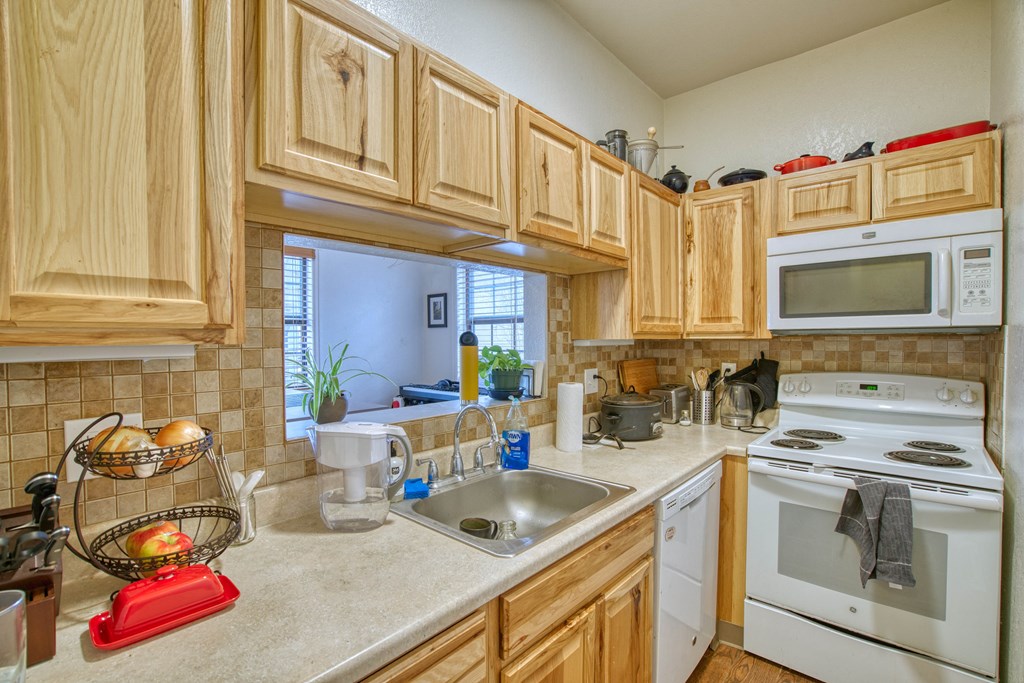 a kitchen with white appliances and wooden cabinets