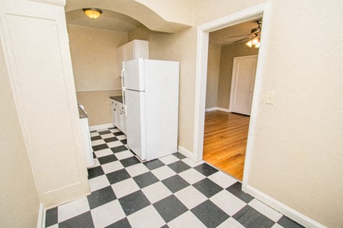 a kitchen with a checkered floor and a white refrigerator
