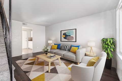 A living room with a white couch, a coffee table, and a painting on the wall.