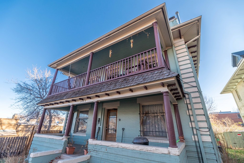 A two-story house with a balcony on the upper level.
