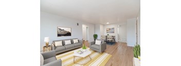 A living room with a grey couch, a coffee table, and a painting on the wall.
