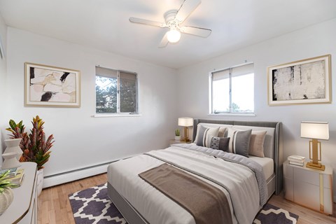A bedroom with a large bed and a ceiling fan.