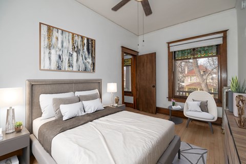 A bedroom with a large bed and a painting on the wall.