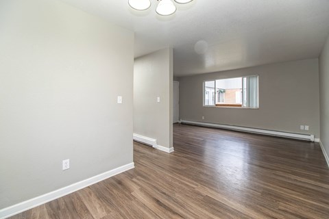 A room with wooden flooring and a window.
