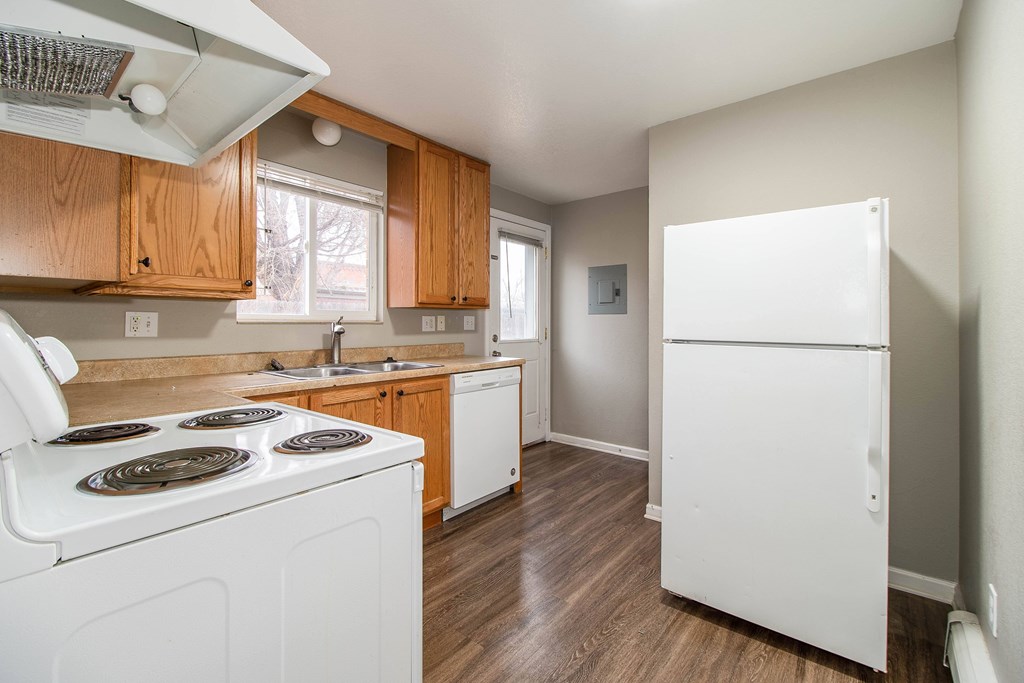 A white stove top oven with a white refrigerator in a kitchen.