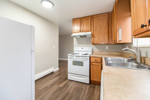 A kitchen with a white oven and wooden cabinets.