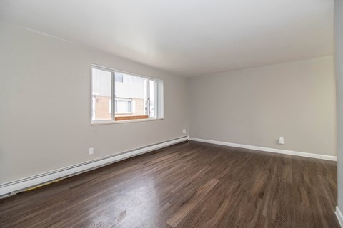 A room with wooden flooring and a window.