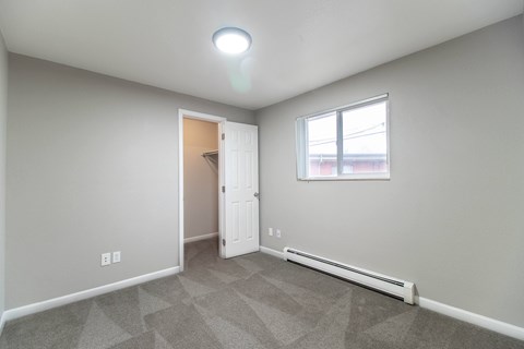 A room with a carpeted floor and a window.