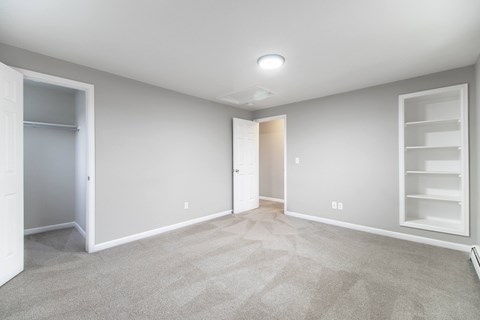 A spacious room with a carpeted floor and white walls.