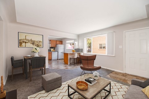 A living room with a grey sofa, a coffee table, and a painting on the wall.