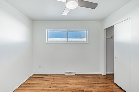 A room with a window and a ceiling fan.