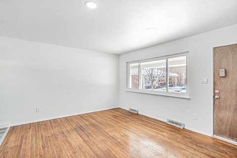 A room with a brown door and a window showing a snowy scene outside.