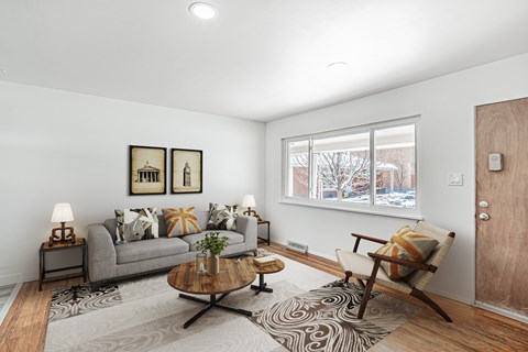 A living room with a grey couch, a coffee table, and a chair.