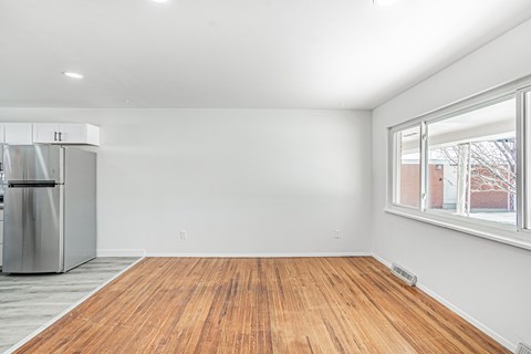 A room with a wooden floor and a window.