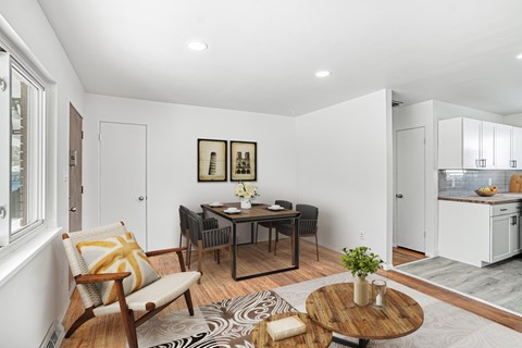 A modern living room with a dining table and chairs.
