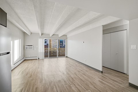 A spacious room with wooden floors and white walls.