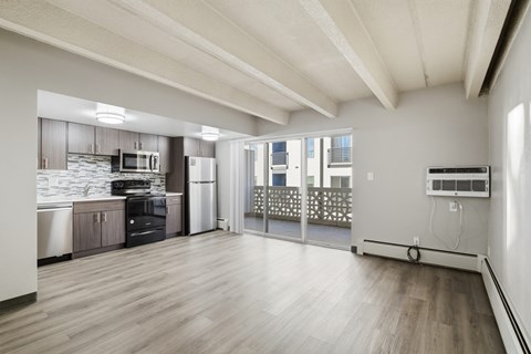 A kitchen with a refrigerator, microwave, and oven.